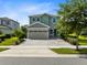 Two-story house with gray siding, shutters, and a paver driveway at 7443 Marker Ave, Kissimmee, FL 34747