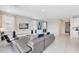 Spacious living area features a gray sectional and access to kitchen and hallway at 7443 Marker Ave, Kissimmee, FL 34747