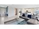 Open living room features a gray sectional and access to the kitchen and entryway at 7443 Marker Ave, Kissimmee, FL 34747