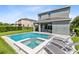 Modern pool and spa with lounge chairs in a grassy backyard at 7443 Marker Ave, Kissimmee, FL 34747
