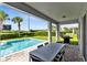 Inviting pool area with covered patio, outdoor dining set, and grill at 7443 Marker Ave, Kissimmee, FL 34747
