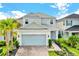 Two-story house with light gray siding, gray garage door, and landscaped yard at 2723 Plume Rd, Clermont, FL 34711