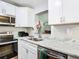 Modern kitchen featuring white cabinets, marble countertops, and stainless steel appliances at 240 People St, Maitland, FL 32751