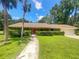 Single-story home with red door and landscaping at 854 Riverbend Blvd, Longwood, FL 32779