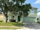 Two-story house with green exterior, arched entryway, and a two-car garage at 366 Fairfield Dr, Sanford, FL 32771
