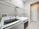 Bright laundry room with washer, dryer, and overhead shelving at 8851 Sperry St, Orlando, FL 32827