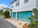 Two-car garage with teal doors and a separate entrance at 8851 Sperry St, Orlando, FL 32827