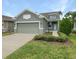 Front view of a two-car garage house with landscaping at 3402 Sagebrush St, Harmony, FL 34773