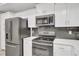 Modern kitchen with white cabinets, black appliances, and quartz countertops at 4721 Clock Tower Dr # 108, Kissimmee, FL 34746