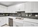 Kitchen with white cabinets, dark tile backsplash, and stainless steel dishwasher at 4721 Clock Tower Dr # 108, Kissimmee, FL 34746