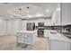Modern kitchen with island, white cabinets, and stainless steel appliances at 4721 Clock Tower Dr # 108, Kissimmee, FL 34746