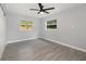 Bright bedroom with ceiling fan, grey tile floors and two windows at 2524 Dellwood Dr, Orlando, FL 32806