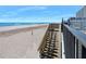 Private beach access with wooden steps leading to the sand at 1404 N Atlantic Ave # 4, Daytona Beach, FL 32118