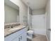 Bathroom with granite countertop, white vanity, and a bathtub at 1502 Jadewood Way, Kissimmee, FL 34744
