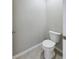 Small powder room with toilet and grey tile floor at 1502 Jadewood Way, Kissimmee, FL 34744