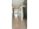 Long hallway with tile flooring and access to various rooms of the house at 1502 Jadewood Way, Kissimmee, FL 34744