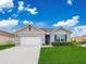 Single-story home with a two-car garage and neatly landscaped front yard at 1502 Jadewood Way, Kissimmee, FL 34744