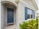 Front entrance of the home, featuring a blue door and teal shutters at 1502 Jadewood Way, Kissimmee, FL 34744