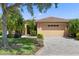 Tan house with tile roof, two-car garage, and landscaped yard at 343 Indian Wells Ave, Kissimmee, FL 34759