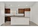 Modern kitchen with island, stainless steel appliances, and dark cabinets at 607 Alder Ln, Auburndale, FL 33823