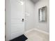 Bright entryway with tile flooring, white door, and a large mirror at 7740 Sandy Ridge Dr # 100, Reunion, FL 34747