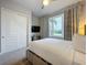 Spacious bedroom with a queen bed and large window with view at 7740 Sandy Ridge Dr # 100, Reunion, FL 34747