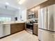 Modern kitchen with stainless steel appliances and dark brown cabinets at 14501 Grove Resort Ave # 3132, Winter Garden, FL 34787