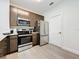 Modern kitchen with stainless steel appliances and dark brown cabinets at 14501 Grove Resort Ave # 3132, Winter Garden, FL 34787