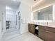 Double vanity bathroom with a large mirror and walk-in shower at 14501 Grove Resort Ave # 3132, Winter Garden, FL 34787