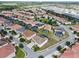 Aerial view of a residential community with tile roofs, pools, and green spaces at 7001 Oakwood St, Davenport, FL 33837