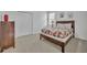 Cozy bedroom with wooden furniture, patterned bedding, and carpeted floors at 7001 Oakwood St, Davenport, FL 33837