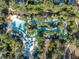 Winding lazy river with blue lounge chairs and umbrellas, surrounded by trees at 7009 Oakwood St, Davenport, FL 33837