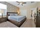 Main bedroom with king-size bed and wood-paneled accent wall at 5424 Solterra Cir # 1, Davenport, FL 33837