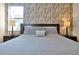 Main bedroom with king-size bed and wood-paneled accent wall at 5424 Solterra Cir # 1, Davenport, FL 33837