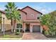 Two-story house with a pink facade, brick driveway, and landscaping at 5424 Solterra Cir # 1, Davenport, FL 33837