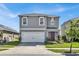 Two-story home with gray siding, two-car garage, and manicured lawn at 117 Eagleview Loop, Davenport, FL 33837