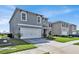 Two-story home with gray siding, a two-car garage, and landscaping at 117 Eagleview Loop, Davenport, FL 33837