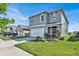 Two-story home with gray siding, a two-car garage, and landscaping at 117 Eagleview Loop, Davenport, FL 33837
