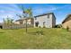 Spacious backyard with a two-story home and green grass at 117 Eagleview Loop, Davenport, FL 33837