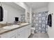 Double vanity bathroom with patterned shower curtain at 117 Eagleview Loop, Davenport, FL 33837