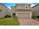 Two-story house with a two-car garage and brick driveway at 8217 De Haven Street, Orlando, FL 32832