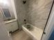 Updated bathroom with a bathtub and marble-style tile at 830 Wooden Blvd, Orlando, FL 32805
