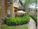 Ground floor patio with seating area and umbrella, surrounded by lush landscaping at 6320 Raleigh St # 604, Orlando, FL 32835