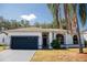 Well-maintained home with a dark gray garage door and palm tree at 573 Hummingbird Ct, Kissimmee, FL 34759