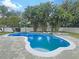 Freeform swimming pool with surrounding brick pavers and palm trees at 15106 Ovation Dr, Winter Garden, FL 34787