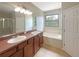 Bathroom with double vanity, garden tub, and window at 15106 Ovation Dr, Winter Garden, FL 34787