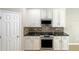 Kitchen with white cabinets, granite countertops, and stainless steel appliances at 15106 Ovation Dr, Winter Garden, FL 34787