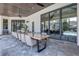 Covered patio with a long wooden table, chairs, and views of the pool at 16828 Vinci Way, Montverde, FL 34756