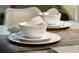 Modern dining setting with white dishware on a glass-top table at 3211 Gold Ln, Kissimmee, FL 34747