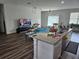 Open concept kitchen and living area with an island and hardwood floors at 120 Zinnia W Ln, Kissimmee, FL 34759